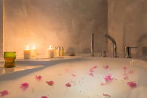 bath with bubbles, flower petals and candles