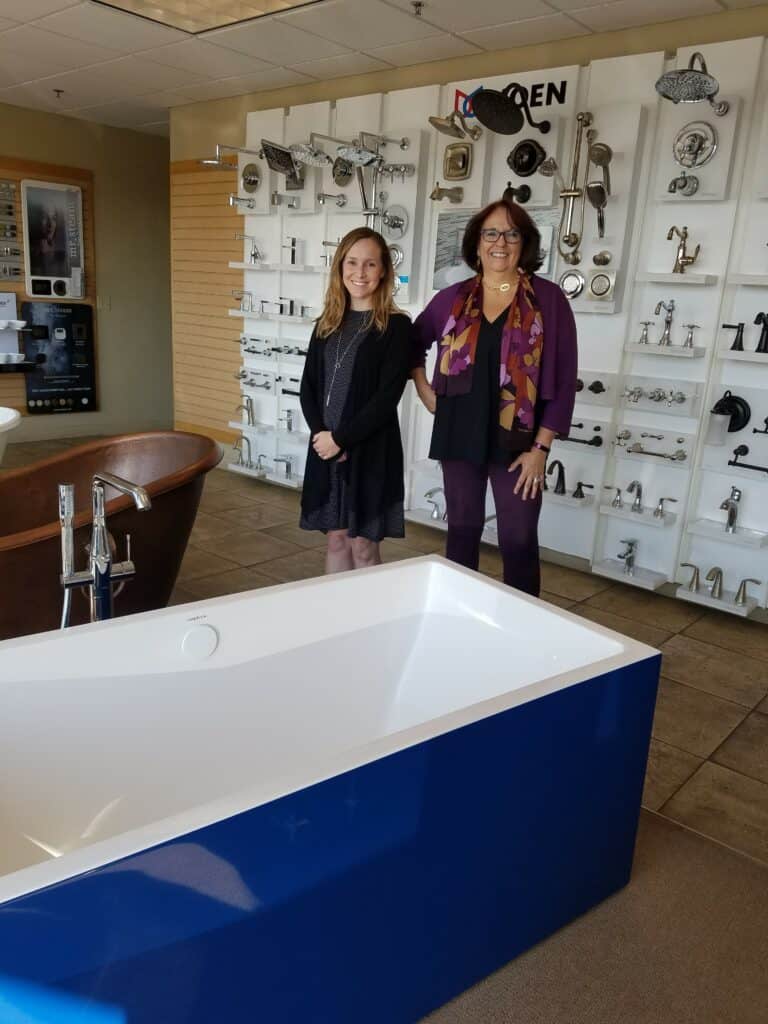 Inline image showing two sales reps standing by a blue Americh stand alone tub.