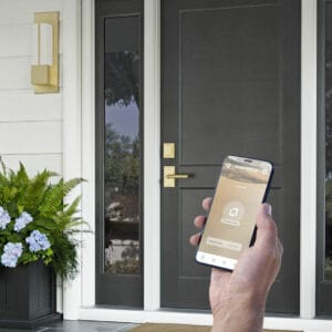 Featured image showing a modern front door with a smart lock from Rocky Mountain Hardware. Homeowner using an app to unlock the door.