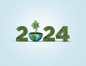 FEatured image showing the numbers 2024 in green luscious plants and a tree sprouting out of earth. Earth day 2024 concept.