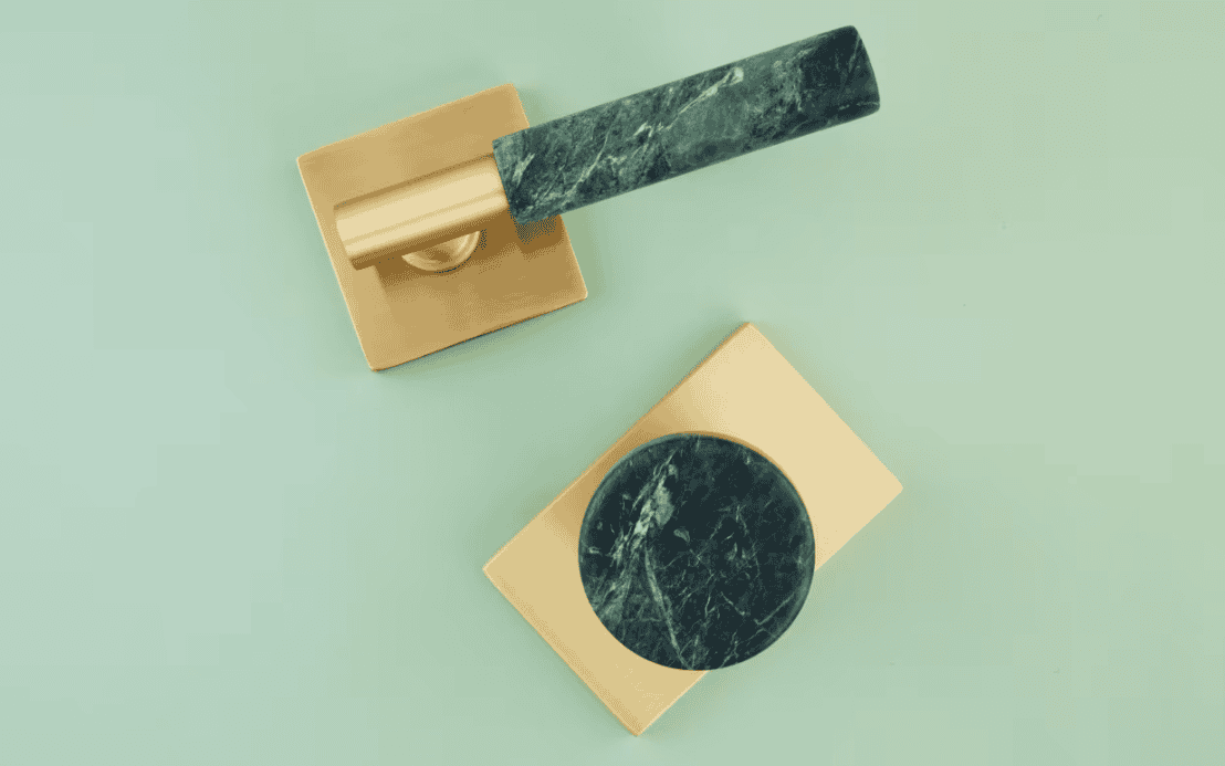 Featured product image showing Emtek's new SELECT green marble hand pulls and knob set on on satin brass square and rectangular rosette plates on a light green background.