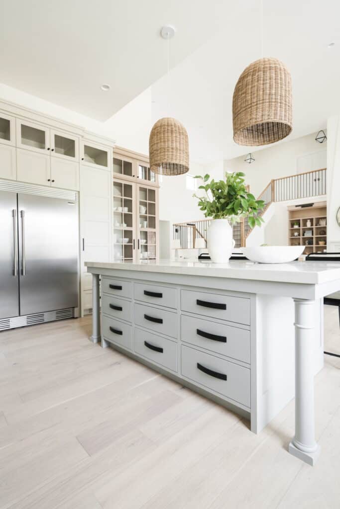 Inline image showing a modern kitchen with white cabinets, natural elements, and custom drawer pulls and handles from Schaub