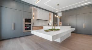 Featured image showing an ultra modern luxury kitchen created by Bahar Zaeem and Shima Radfar of RZ Interiors. Include floor to ceiling storage, floating island made of marble and open layout. Featured in KBIS.