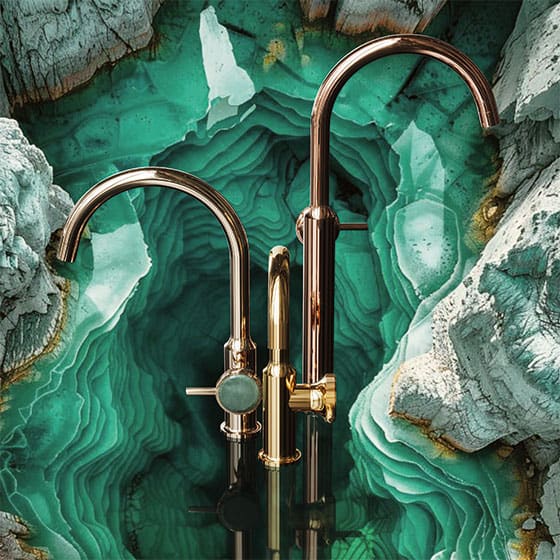 Featured image showing Jörger's new Valencia faucets in a brass finish with green aventurine knobs displayed in front of a marbled Green Aventurine slab. 