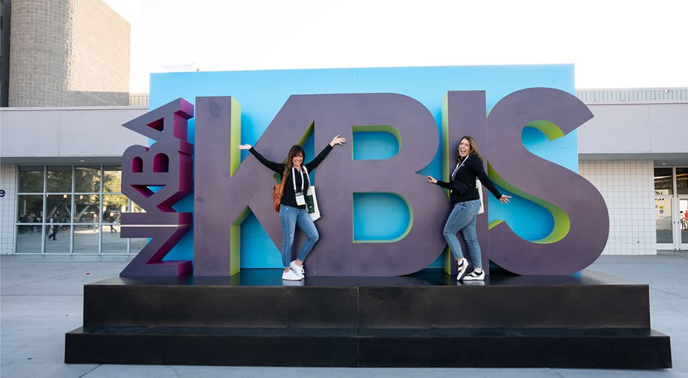 Featured image showing the KBIS sign with two attendees posing for the camera.